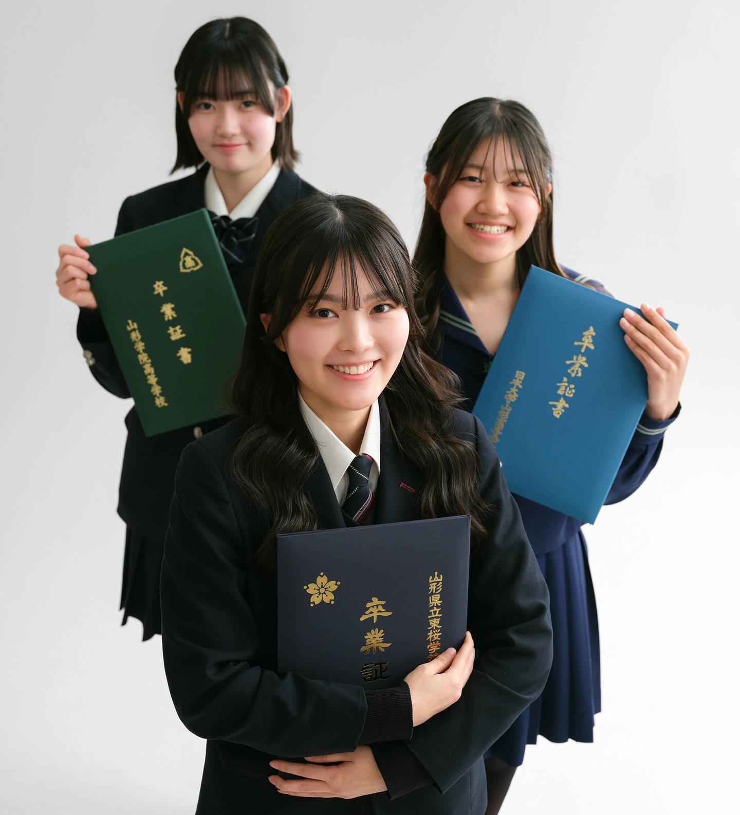 卒業証書を手に寄り添う、制服姿の3人の友フォト